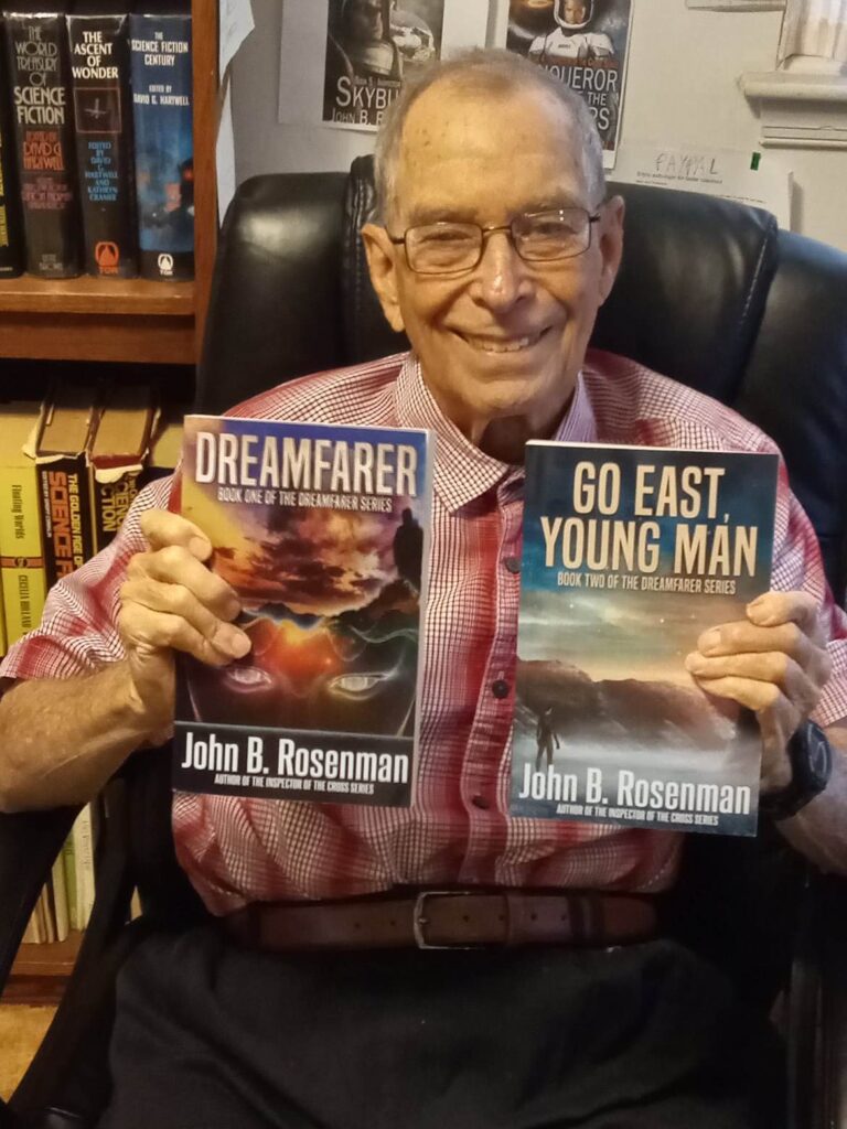 A man sitting in a chair holding two books.